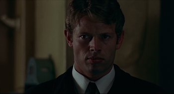 Movie still from “The Red Circle” (1970), directed by Jean-Pierre Melville – A person wearing a suit and tie; Close Up shot, Low angle