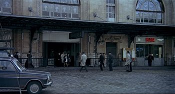 Movie still from “The Red Circle” (1970), directed by Jean-Pierre Melville – A group of people walking down a street; Extreme Wide shot, High angle