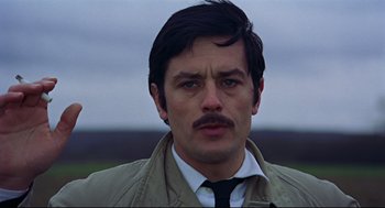 Movie still from “The Red Circle” (1970), directed by Jean-Pierre Melville – A person wearing a suit and tie; Close Up shot, Low angle