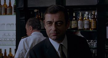 Movie still from “The Red Circle” (1970), directed by Jean-Pierre Melville – A person wearing a suit and tie; Close Up shot, Low angle
