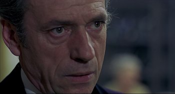 Movie still from “The Red Circle” (1970), directed by Jean-Pierre Melville – A man's face as he stares into the distance; Close Up shot, Over the shoulder angle