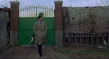 Movie still from “The Red Circle” (1970), directed by Jean-Pierre Melville – A man in a trench coat and a dog; Wide shot, Low angle
