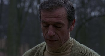 Movie still from “The Red Circle” (1970), directed by Jean-Pierre Melville – An older man in a sweater is looking down at his face; Close Up shot, Low angle