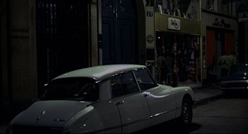 Movie still from “The Red Circle” (1970), directed by Jean-Pierre Melville – An old car parked on the side of the street; Wide shot, High angle