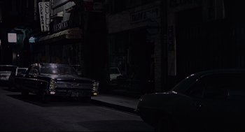 Movie still from “The Red Circle” (1970), directed by Jean-Pierre Melville – Cars parked on the side of the street at night; Extreme Wide shot, High angle