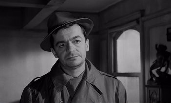 Movie still from “Le Doulos” (1962), directed by Jean-Pierre Melville – Black and white photograph of a man wearing a hat; Close Up shot, Over the shoulder angle