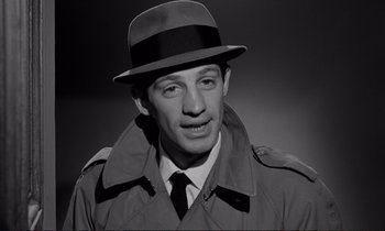 Movie still from “Le Doulos” (1962), directed by Jean-Pierre Melville – A black and white photo of a man wearing a hat; Close Up shot, High angle