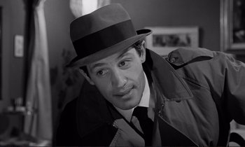 Movie still from “Le Doulos” (1962), directed by Jean-Pierre Melville – A black and white photo of a man wearing a hat; Close Up shot, High angle