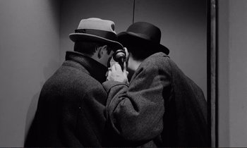 Movie still from “Le Doulos” (1962), directed by Jean-Pierre Melville – A couple of men standing next to each other; Close Up shot, Overhead angle