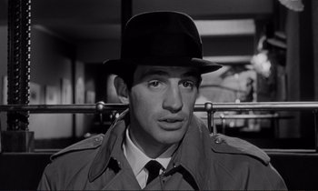 Movie still from “Le Doulos” (1962), directed by Jean-Pierre Melville – A black and white photo of a man wearing a hat; Close Up shot, Low angle
