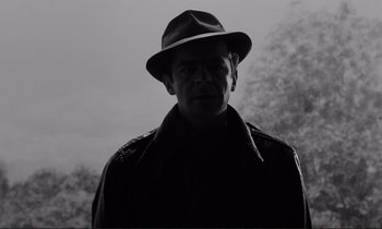 Movie still from “Le Doulos” (1962), directed by Jean-Pierre Melville – A black and white photo of a man wearing a hat; Close Up shot, Low angle