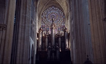 Movie still from “Le Grand Amour” (1969), directed by Pierre Étaix – A large cathedral with a stained - glass window; Extreme Wide shot, High angle