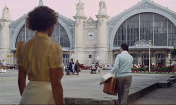 Movie still from “Le Grand Amour” (1969), directed by Pierre Étaix – A man and a woman are standing in front of a clock tower; Extreme Wide shot, Low angle