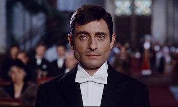 Movie still from “Le Grand Amour” (1969), directed by Pierre Étaix – A person wearing a suit and bow tie; Close Up shot, Low angle