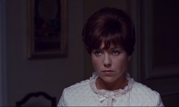Movie still from “Le Grand Amour” (1969), directed by Pierre Étaix – A person with short hair wearing a white shirt; Close Up shot, Over the shoulder angle