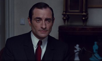 Movie still from “Le Grand Amour” (1969), directed by Pierre Étaix – A person wearing a suit and tie; Close Up shot, Over the shoulder angle