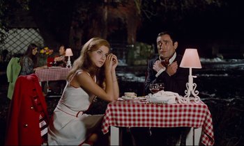 Movie still from “Le Grand Amour” (1969), directed by Pierre Étaix – A man and a woman sitting at a dinner table; Medium shot, Low angle