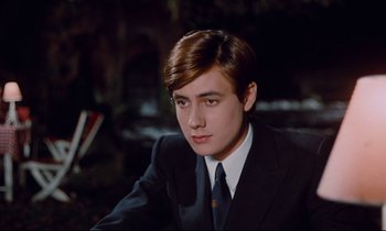 Movie still from “Le Grand Amour” (1969), directed by Pierre Étaix – A man in a suit and tie sitting in a chair; Close Up shot, High angle