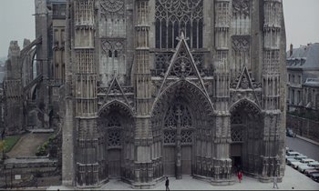 Movie still from “Le Grand Amour” (1969), directed by Pierre Étaix – A large cathedral with many windows and arches; Extreme Wide shot, High angle
