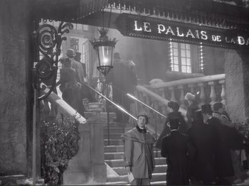 Movie still from “Le Plaisir” (1952), directed by Max Ophüls – A black and white photo of people walking down a staircase; Wide shot, Low angle