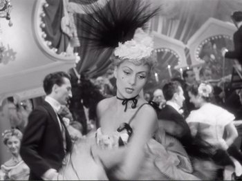 Movie still from “Le Plaisir” (1952), directed by Max Ophüls – A black and white photo of a woman in a fancy hat; Medium shot, Low angle