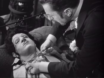 Movie still from “Le Plaisir” (1952), directed by Max Ophüls – An old photo of a man tying a woman's neck tie; Medium shot, High angle