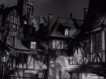 Movie still from “Le Plaisir” (1952), directed by Max Ophüls – A black - and - white photo of a medieval town; Extreme Wide shot, Low angle