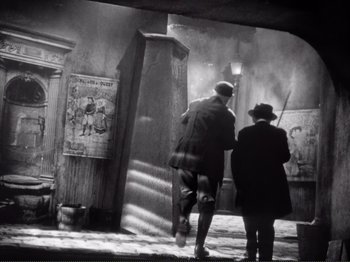 Movie still from “Le Plaisir” (1952), directed by Max Ophüls – A man and a woman are walking in the dark; Wide shot, Low angle