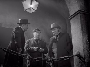 Movie still from “Le Plaisir” (1952), directed by Max Ophüls – A group of men standing next to each other; Medium shot, High angle