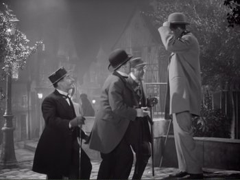 Movie still from “Le Plaisir” (1952), directed by Max Ophüls – A group of men standing next to each other on a street; Wide shot, Low angle