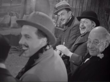 Movie still from “Le Plaisir” (1952), directed by Max Ophüls – A black and white photo of a group of men in hats; Medium shot, High angle