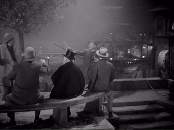 Movie still from “Le Plaisir” (1952), directed by Max Ophüls – An old photo of a man on a park bench; Wide shot, High angle