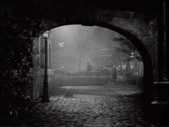 Movie still from “Le Plaisir” (1952), directed by Max Ophüls – An arch in the middle of a street at night; Extreme Wide shot, High angle
