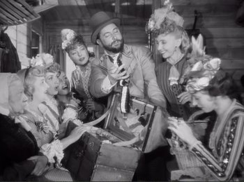 Movie still from “Le Plaisir” (1952), directed by Max Ophüls – A group of people standing next to each other; Medium shot, Low angle