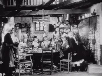 Movie still from “Le Plaisir” (1952), directed by Max Ophüls – A group of people sitting around a table; Wide shot, High angle