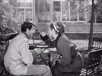 Movie still from “Le Plaisir” (1952), directed by Max Ophüls – A man and a woman sitting at an outdoor table; Medium shot, High angle