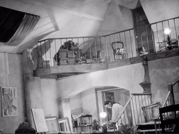 Movie still from “Le Plaisir” (1952), directed by Max Ophüls – An old photo of a man working in an attic; Wide shot, Low angle