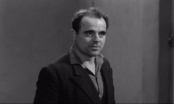 Movie still from “The Hole” (1960), directed by Jacques Becker – Black and white photograph of a man wearing a suit; Close Up shot, Low angle