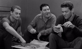 Movie still from “The Hole” (1960), directed by Jacques Becker – A group of men sitting on the ground eating food; Medium shot, High angle