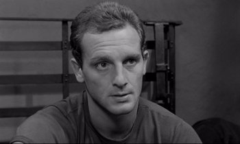 Movie still from “The Hole” (1960), directed by Jacques Becker – Black and white photograph of a man in a chair; Close Up shot, High angle