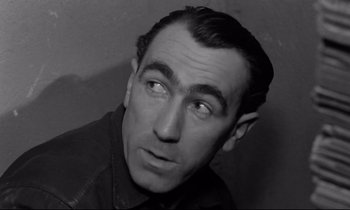 Movie still from “The Hole” (1960), directed by Jacques Becker – Black and white photograph of a man looking up; Close Up shot, High angle