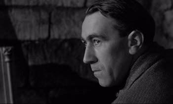 Movie still from “The Hole” (1960), directed by Jacques Becker – Black and white photograph of a man looking to his left; Close Up shot, Low angle