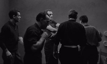 Movie still from “The Hole” (1960), directed by Jacques Becker – A black and white photo of a group of men; Medium shot, Low angle