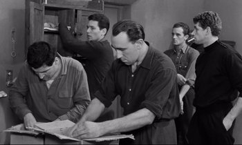 Movie still from “The Hole” (1960), directed by Jacques Becker – A black and white photo of a group of men working together; Medium shot, Low angle