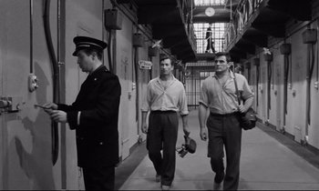 Movie still from “The Hole” (1960), directed by Jacques Becker – A group of men walking down a hall way; Medium shot, Low angle