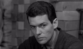 Movie still from “The Hole” (1960), directed by Jacques Becker – Black and white photograph of a man with a sweater on; Close Up shot, High angle