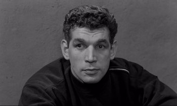 Movie still from “The Hole” (1960), directed by Jacques Becker – Black and white photograph of a young man with curly hair; Close Up shot, High angle