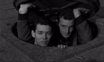 Movie still from “The Hole” (1960), directed by Jacques Becker – A couple of men standing next to each other; Medium shot, High angle