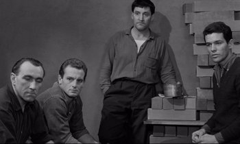 Movie still from “The Hole” (1960), directed by Jacques Becker – A black and white photo of two men standing next to each other; Medium shot, Low angle