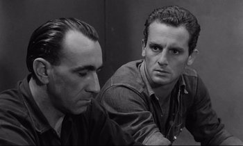 Movie still from “The Hole” (1960), directed by Jacques Becker – A black - and - white photo of two men sitting next to each other; Close Up shot, High angle